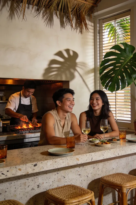 Tungku — friends over wine at a terrazzo counter while the chef works the open charcoal grill